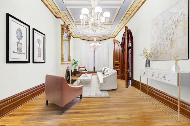 sitting room featuring crown molding, light wood-type flooring, an inviting chandelier, and coffered ceiling