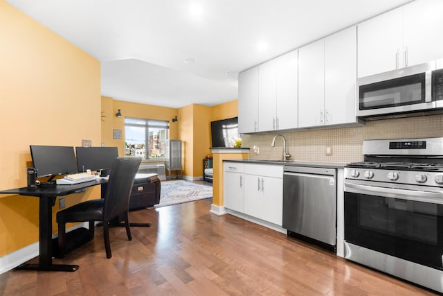 3312 Hudson Ave Unit 3L, Union City, NJ 07087 - kitchen with appliances with stainless steel finishes, decorative backsplash, wood finished floors, and white cabinetry