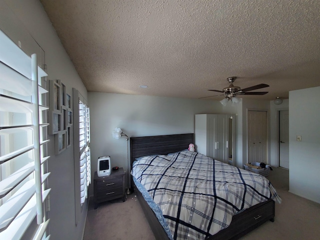 bedroom featuring a textured ceiling, two closets, a ceiling fan, and carpet floors