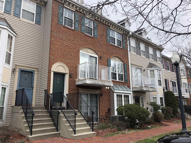 view of front of home with central air condition unit and brick siding