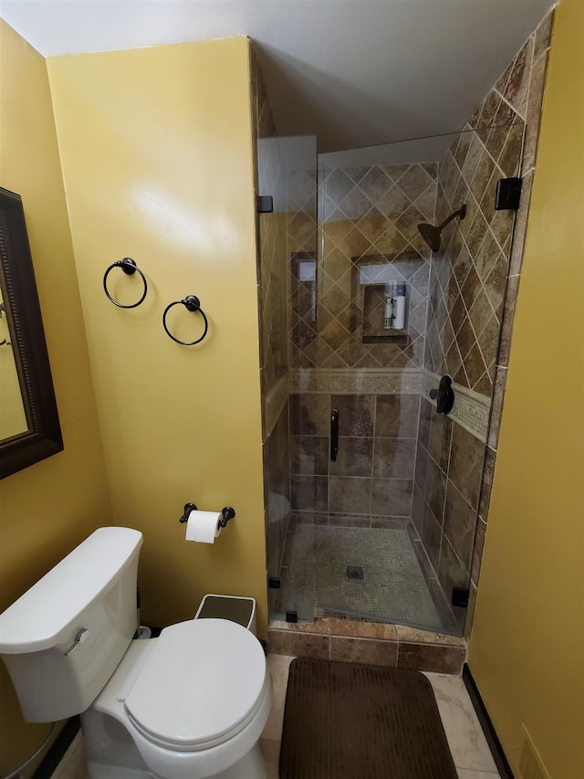 bathroom with toilet, marble finish floor, and a stall shower