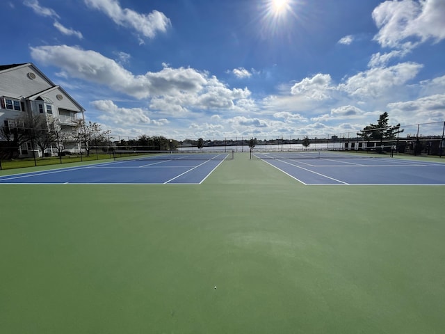 view of tennis court featuring fence