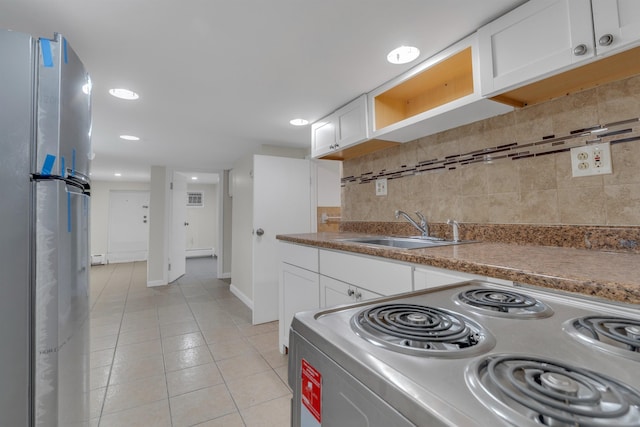 kitchen featuring white cabinetry, stainless steel fridge, sink, and range