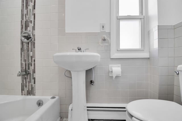 bathroom with a bathtub, tile walls, and toilet