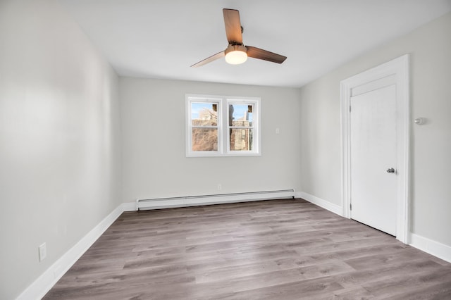 spare room with ceiling fan, light hardwood / wood-style flooring, and a baseboard heating unit