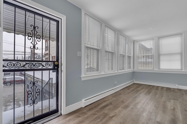 interior space featuring hardwood / wood-style flooring, plenty of natural light, and baseboard heating