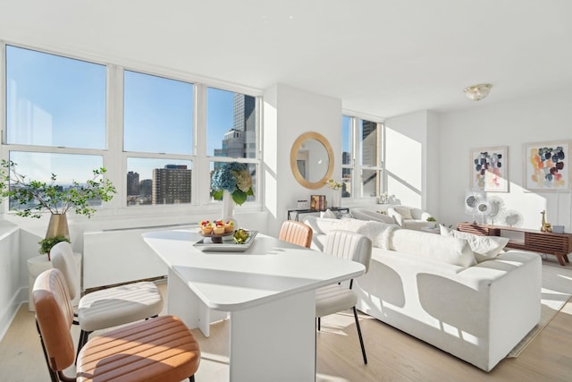 dining area with a wealth of natural light and light hardwood / wood-style flooring