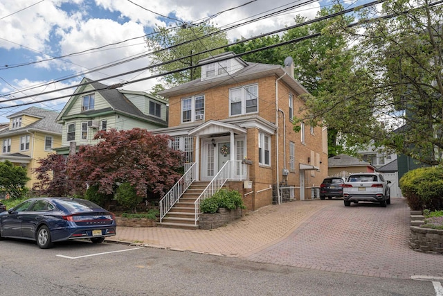 american foursquare style home featuring brick siding