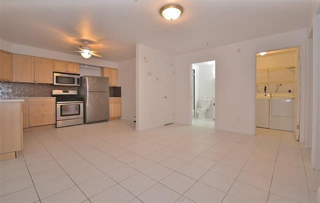 55 71st St, Guttenberg, NJ 07093 - kitchen with stainless steel appliances, independent washer and dryer, light brown cabinetry, decorative backsplash, and ceiling fan