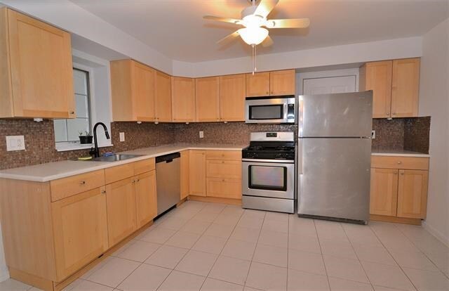 55 71st St, Guttenberg, NJ 07093 - kitchen featuring appliances with stainless steel finishes, a sink, light brown cabinets, decorative backsplash, and ceiling fan