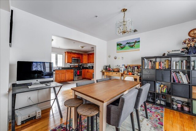 55 71st St, Guttenberg, NJ 07093 - dining area featuring light wood-style floors and a chandelier