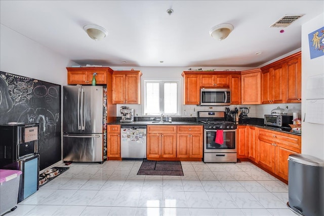 55 71st St, Guttenberg, NJ 07093 - kitchen with stainless steel appliances, light marble finish floors, dark countertops, and brown cabinetry