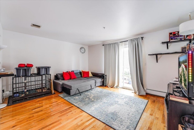 55 71st St, Guttenberg, NJ 07093 - living area featuring a baseboard heating unit and wood finished floors