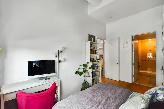 bedroom featuring connected bathroom and wood-type flooring