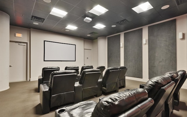 carpeted home theater room featuring a paneled ceiling