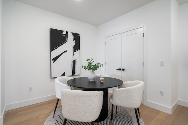 dining room with light wood-type flooring and baseboards