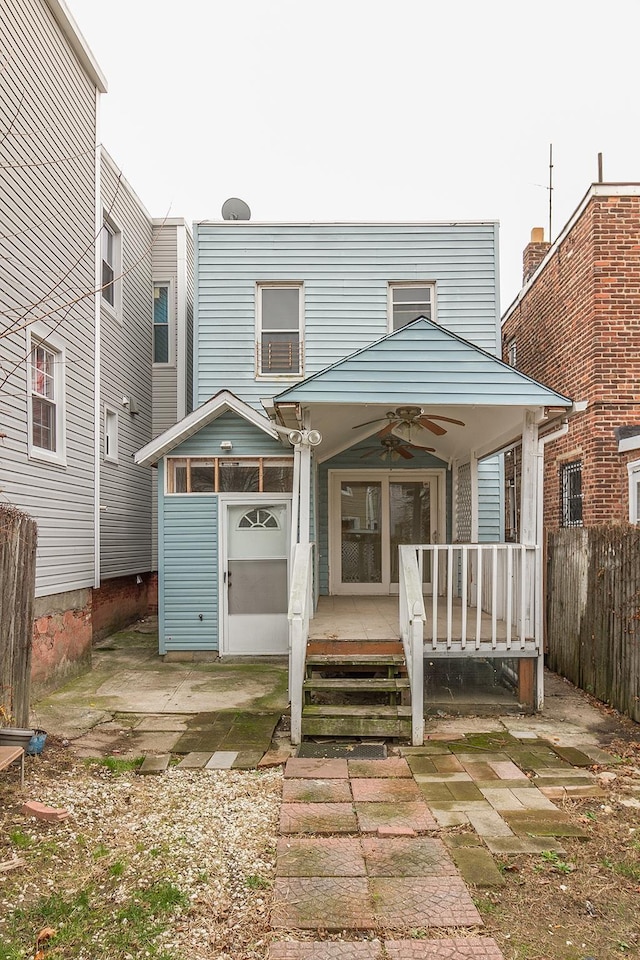 rear view of property featuring a wooden deck, a ceiling fan, and fence