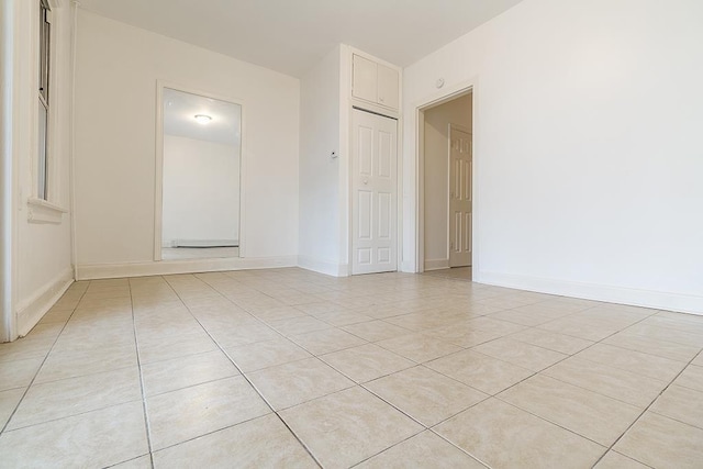 unfurnished room with baseboards and light tile patterned floors