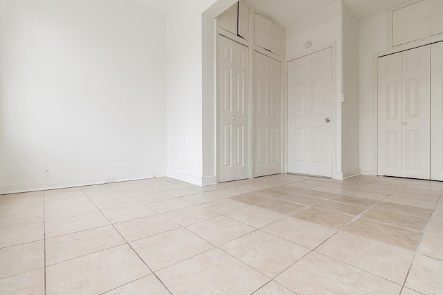 unfurnished bedroom featuring baseboards and light tile patterned floors