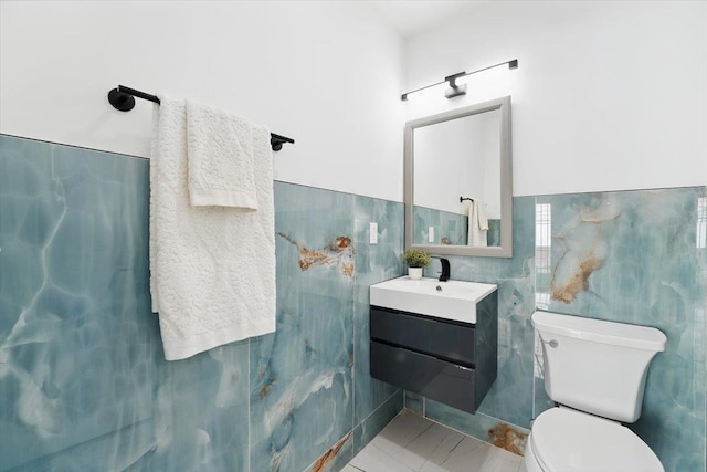 54 Logan Ave Unit 1, Jersey City, NJ 07306 - half bath featuring tile walls, vanity, toilet, a wainscoted wall, and tile patterned floors