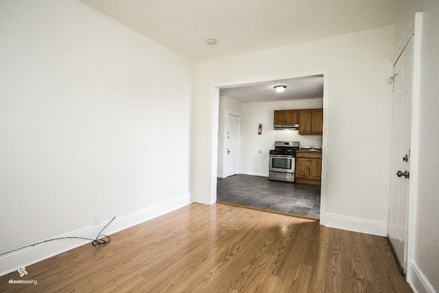 1043 Broadway, Bayonne, NJ 07002 - unfurnished living room with dark wood-style flooring and baseboards
