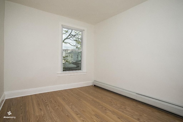 1043 Broadway, Bayonne, NJ 07002 - spare room with a baseboard heating unit, wood finished floors, and baseboards