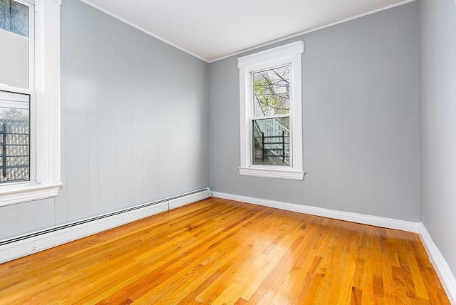 1043 Broadway, Bayonne, NJ 07002 - unfurnished room featuring a baseboard heating unit, wood-type flooring, baseboards, and crown molding