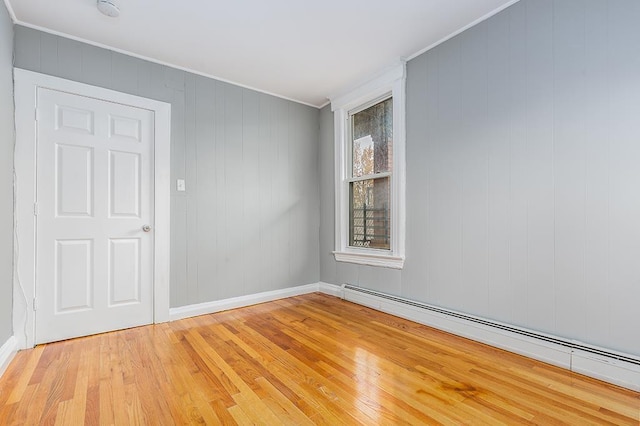 1043 Broadway, Bayonne, NJ 07002 - unfurnished room with a baseboard heating unit, crown molding, light wood-style flooring, and baseboards