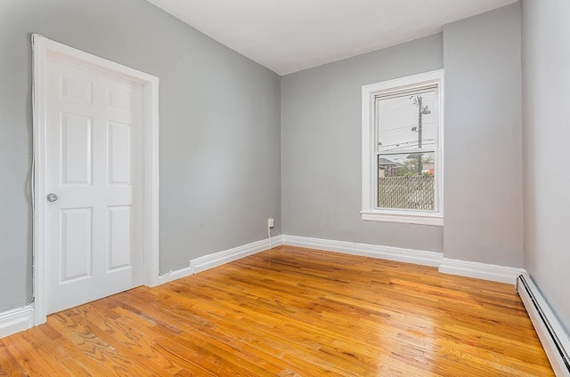 1043 Broadway, Bayonne, NJ 07002 - empty room with baseboard heating, light wood-type flooring, and baseboards