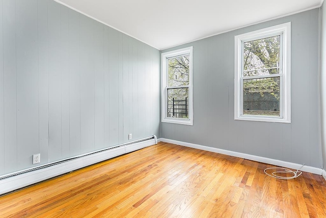 1043 Broadway, Bayonne, NJ 07002 - spare room featuring a baseboard radiator, plenty of natural light, wood finished floors, baseboards, and ornamental molding
