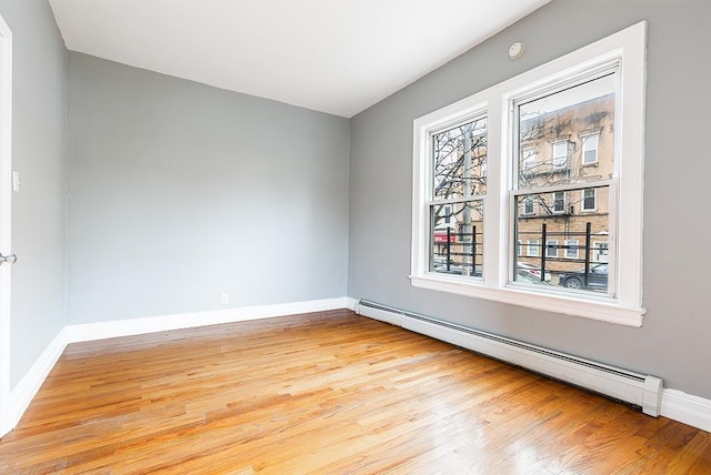 1043 Broadway, Bayonne, NJ 07002 - spare room with baseboard heating, light wood-style floors, and baseboards