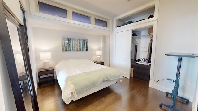 bedroom with dark hardwood / wood-style flooring and a closet