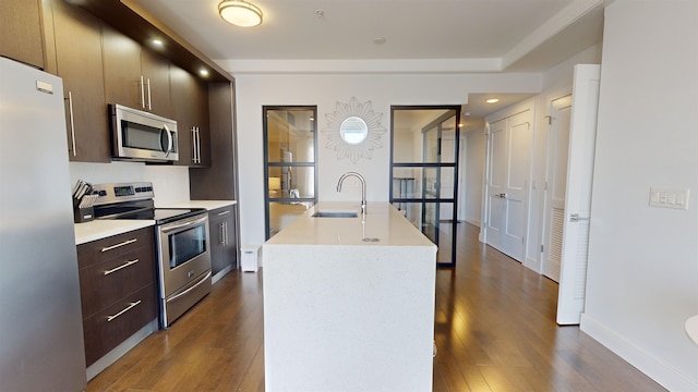 kitchen featuring dark wood-type flooring, an island with sink, appliances with stainless steel finishes, and sink