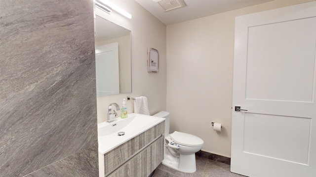 bathroom featuring vanity, tile patterned floors, and toilet