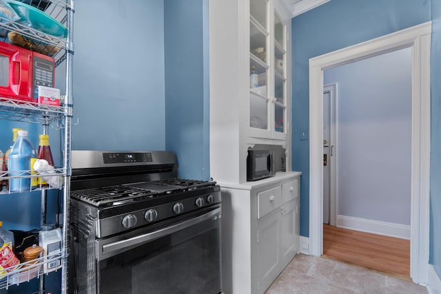 122 W 39th St Unit A4, Bayonne, NJ 07302 - kitchen featuring range with gas stovetop, black microwave, white cabinets, and glass insert cabinets