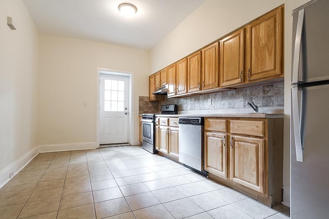 kitchen with stainless steel appliances, tasteful backsplash, light tile patterned flooring, under cabinet range hood, and baseboards