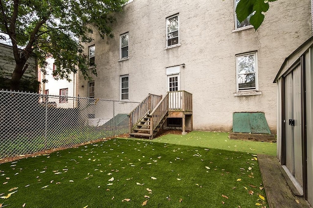 exterior space featuring fence, a lawn, and stucco siding