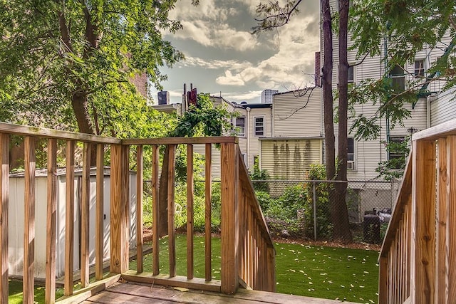 view of gate with a yard, fence, and a wooden deck