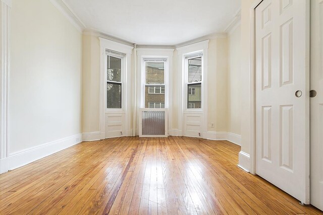 entryway with light wood-style flooring, baseboards, and ornamental molding