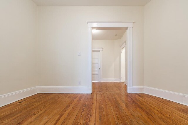 empty room with hardwood / wood-style flooring and baseboards