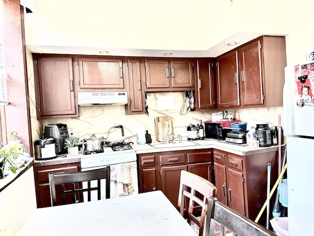 500 New York Ave, Jersey City, NJ 07087 - kitchen featuring white appliances, under cabinet range hood, light countertops, and backsplash