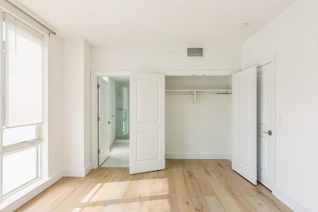 348 Baldwin Ave Unit 209, Jersey City, NJ 07306 - unfurnished bedroom featuring light wood-type flooring, multiple windows, and a closet