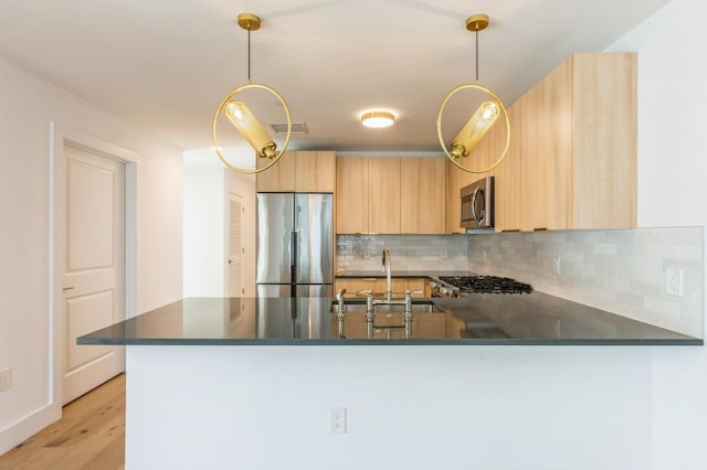 348 Baldwin Ave Unit 209, Jersey City, NJ 07306 - kitchen featuring stainless steel appliances, a sink, light brown cabinetry, backsplash, and a peninsula