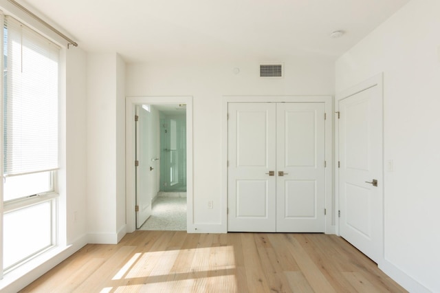 348 Baldwin Ave Unit 209, Jersey City, NJ 07306 - unfurnished bedroom featuring light wood-style flooring, a closet, baseboards, and ensuite bath