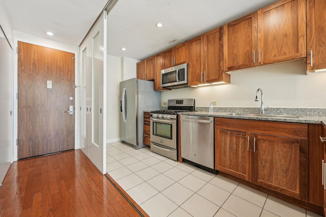 20 Newport Pkwy Unit 1006, Jersey City, NJ 07310 - kitchen with stainless steel appliances, a sink, brown cabinetry, stone counters, and recessed lighting