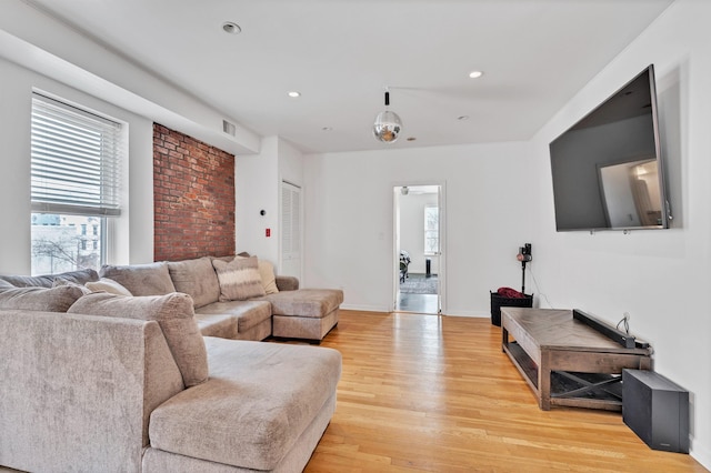 living room featuring ceiling fan, plenty of natural light, and light hardwood / wood-style floors