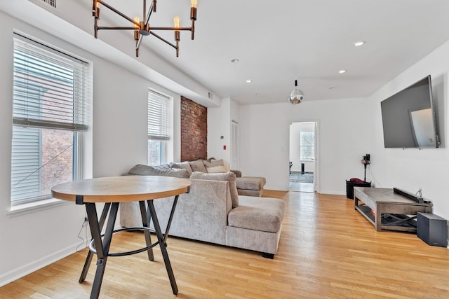 living room featuring light wood-type flooring and a notable chandelier