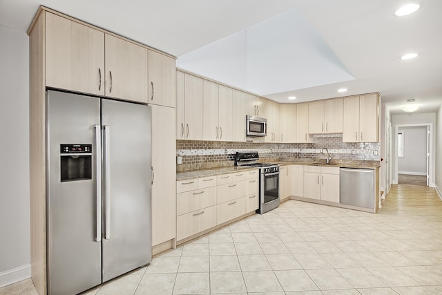 kitchen featuring sink, tasteful backsplash, light tile patterned floors, light brown cabinets, and appliances with stainless steel finishes