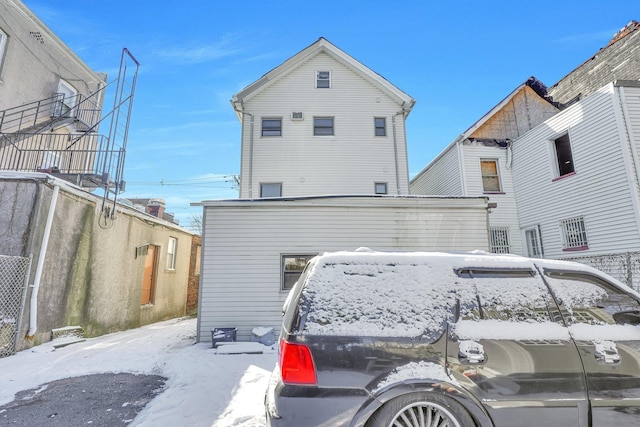 view of snow covered back of property