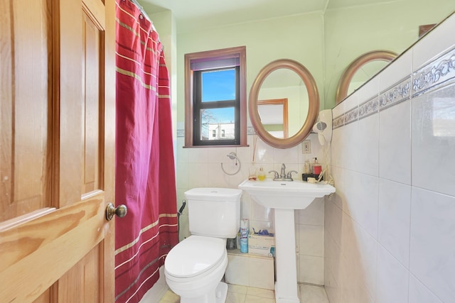 bathroom featuring toilet, tile walls, a shower with curtain, and a sink